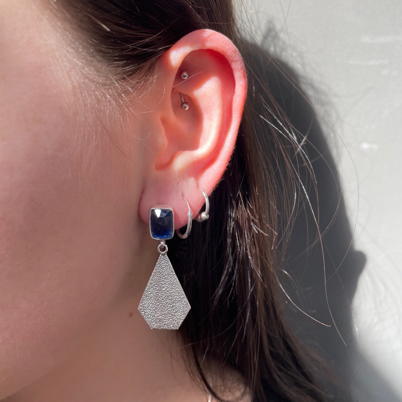 Young woman wearing kyanite and silver earrings.